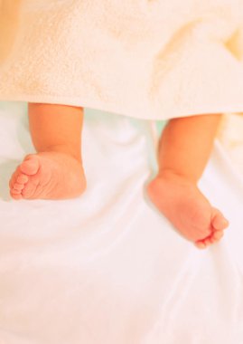 Yatakta yeni doğmuş şirin ayakların yakın çekimi