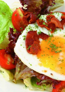 Kızarmış pastırmalı yumurta, roka ve ahşap masada beyaz tabakta domates.