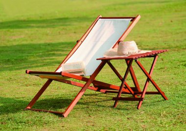 Güneş yatağı ve çimenlikteki ahşap masa.