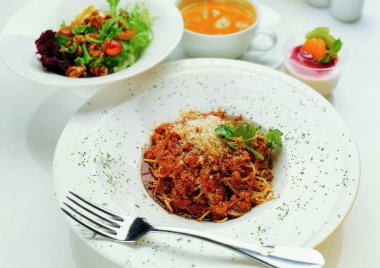 beyaz tabakta et ve sebzeli makarna