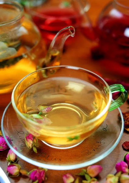 ahşap masa üzerinde çay ve çiçek ile fincan