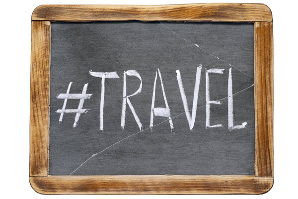 Travel hashtag handwritten on vintage school slate board isolated on white