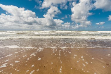 parlak güneşli deniz manzarası ile mavi bulutlu gökyüzü ve boş kum plaj