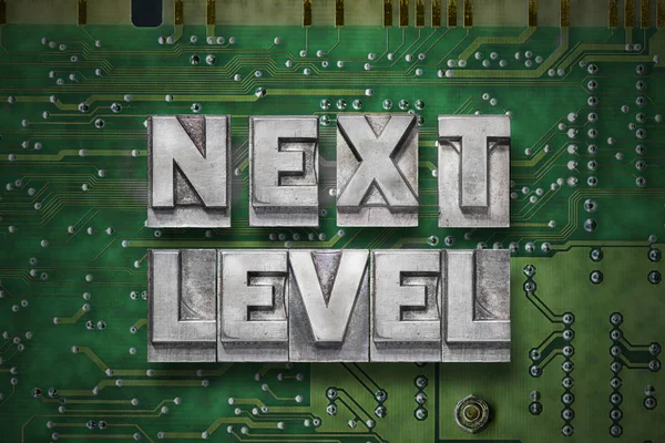 next level phrase made from metallic letterpress blocks on the pc board background