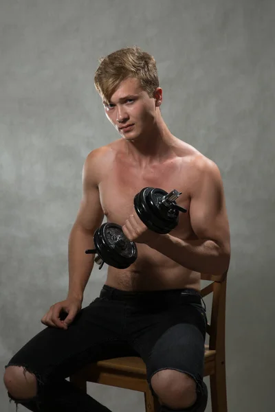 A shoot of young caucasian handsome blonde man against grey background.