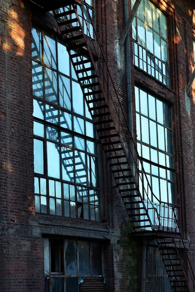 放棄された繊維工場棟大きな窓とファイア エスケープ階段日没でウッチ ポーランド — ストック写真