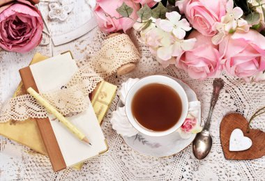 Retro tarzı flatlay çay, planlayıcısı, demet çiçekler ve dantel fincan 