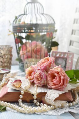 Vintage tarzı natürmort güzel pembe güllü yalan eski kitap, inci ve dantel