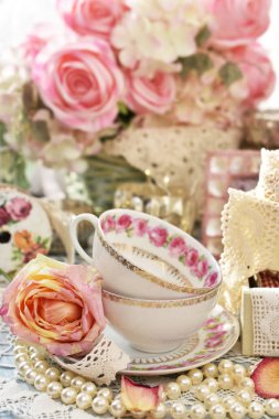 eski püskü şık stil iç dekorasyon porselen çay bardak, dantel ve masanın üzerine pembe gül ile