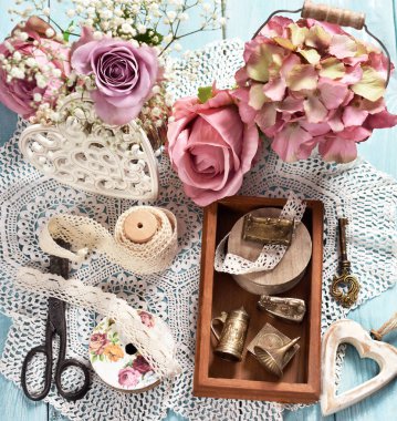 Vintage tarzı eski dantel, minyatür demir nesneleri ahşap kutu ve çiçekler ile düz yatıyordu fotoğraf 