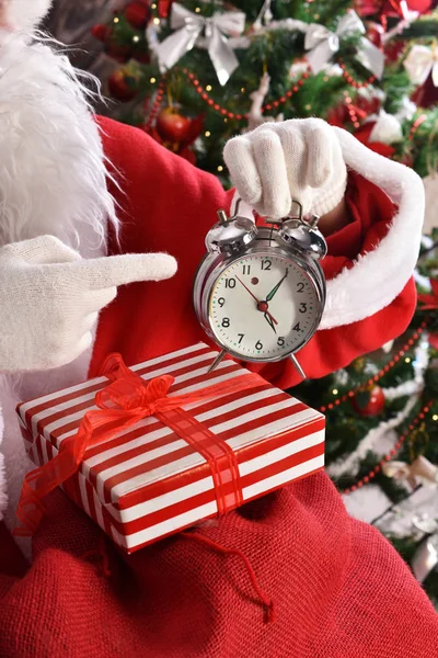 Санта Клаус Сидит Подарками Перед Елкой Показывает Пальцем Будильник — стоковое фото