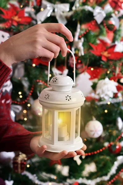 一个女孩的手拿着复古风格的白色蜡烛灯笼在圣诞树前 — 图库照片
