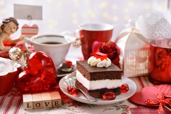 チョコレートとホイップ クリーム ケーキと赤と白の装飾とコーヒーのカップでバレンタインのお祝い — ストック写真