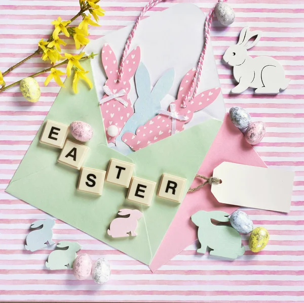 Pasqua piatta giaceva con coniglietto decori in busta sul retro a strisce — Foto Stock