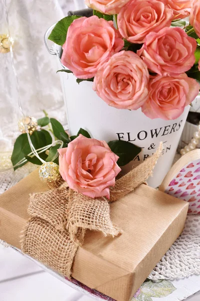 Bunch of roses and a gift in romantic style — Stock Photo, Image