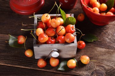 ahşap masa üzerinde taze sarı ve kırmızı kiraz