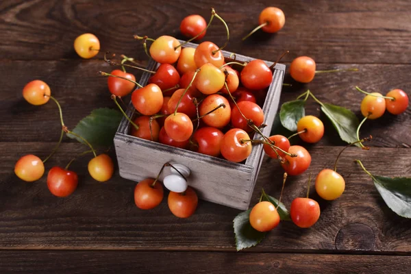 Fresh yellow and red cherries on wooden table — Stock Photo, Image