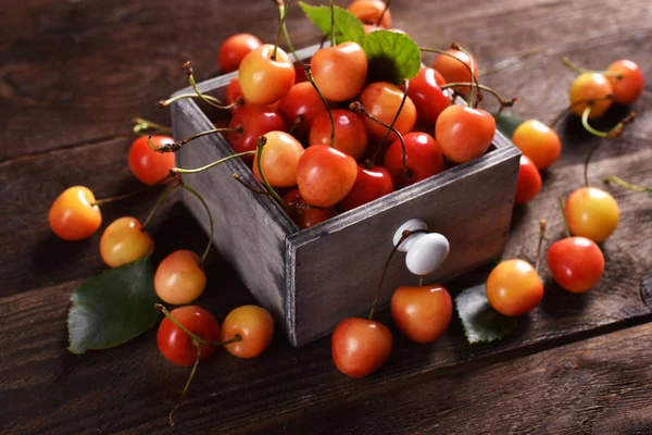 Fresh yellow and red cherries on wooden table — Stock Photo, Image