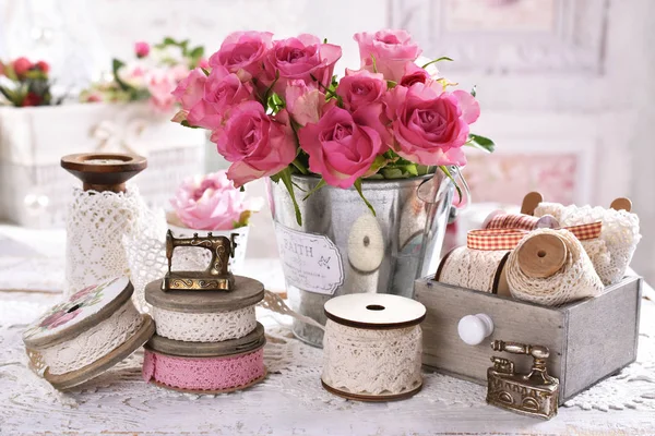 Vintage lace trims on spools and bunch of roses — Stock Photo, Image