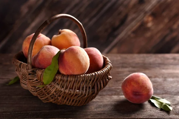 Fresh ripe peaches in a wicker basket — Stock Photo, Image