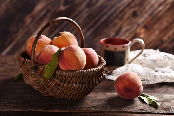 Fresh ripe peaches in a wicker basket — Stock Photo, Image