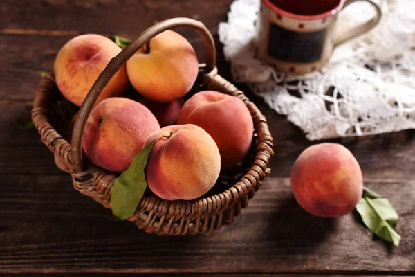 Fresh ripe peaches in a wicker basket — Stock Photo, Image