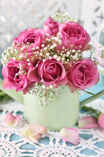 민트 급수 캔에 분홍색 장미의 무리 스톡 이미지