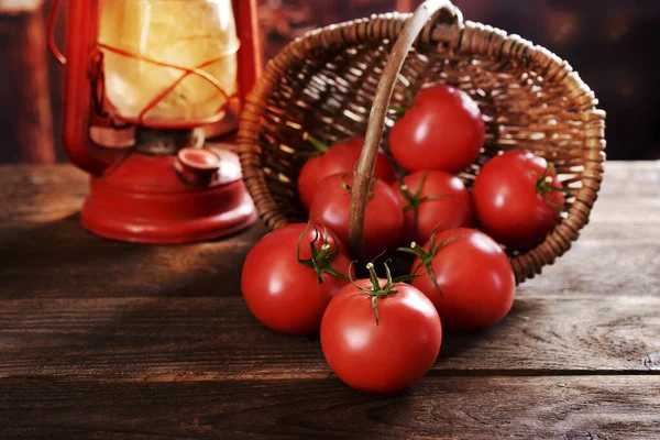 柳条筐里掉出来的新鲜西红柿 放在乡村木桌上 — 图库照片