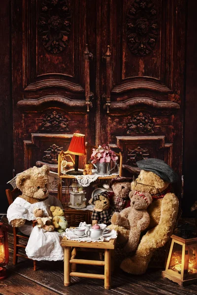 古色古香的泰迪熊一家坐在乡村风格房间的茶几旁 — 图库照片