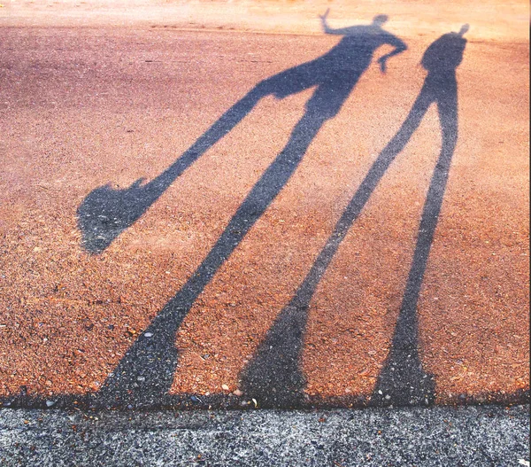 在日出或日落时 一个人沿着路边跳舞的长阴影与复古复古 Instagram 过滤器 — 图库照片