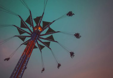 fair swing ride at dusk toned with a retro vintage instagram filter  clipart