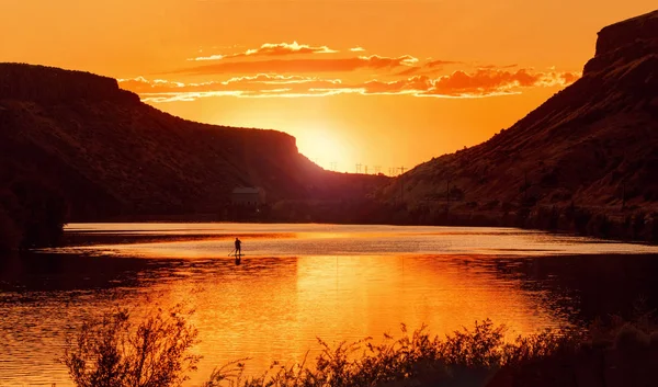 Beautiful sunset over the boise river in idaho with a person on a paddle board — Stock Photo, Image