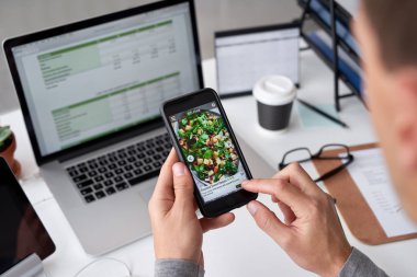 Cep telefonu kullaranarak ile dizüstü bilgisayar masası, yemek siparişi ile mobil ekran iş adamı 