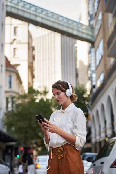 Donna Che Utilizza Telefono Nella Città Europea Mentre Indossa Cuffie — Foto Stock