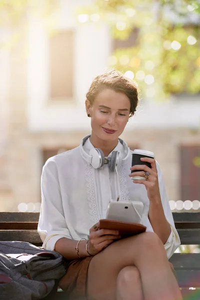 Junge Frau Liest Tablet Und Genießt Kaffee lizenzfreie Stockbilder