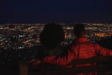 arkadan görünüşü geceleri şehri tepeden bakarak çift 