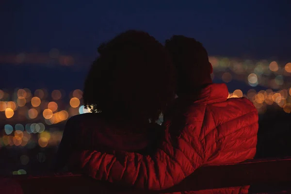 后面的一对夫妇看着城市从山上在晚上 — 图库照片