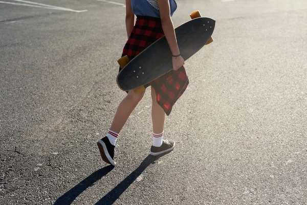 Sorglös skridskoåkare som innehar longboard skateboard Stockbild