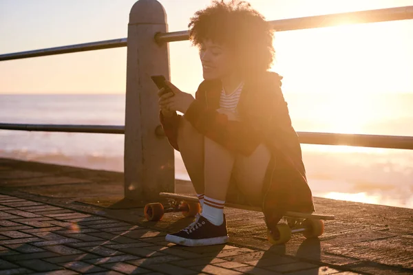 Millennial Frau SMS mit Sonneneruption lizenzfreie Stockfotos