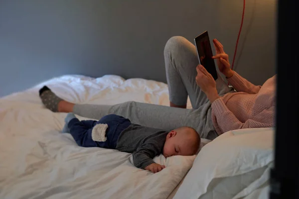 Madre donna utilizzando tablet in camera da letto — Foto Stock