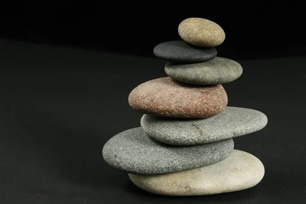 Seven pebbles pyramid over dark — Stock Photo, Image