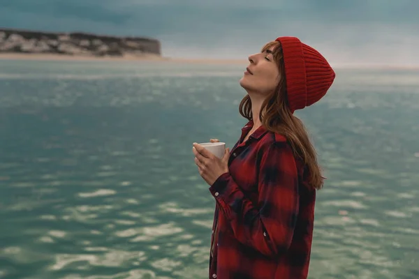 ホット コーヒーのマグカップと湖での時間を楽しむ女性 — ストック写真