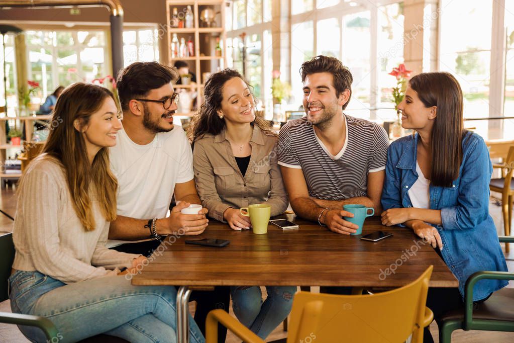 A group of friends talking and drinking coffee at the cafe
