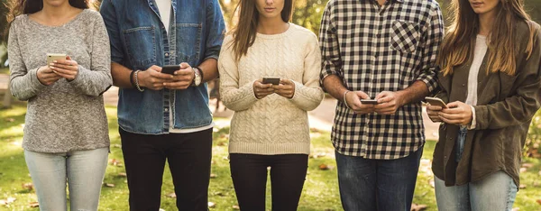 Grupo Amigos Distraídos Con Las Redes Sociales Sus Teléfonos — Foto de Stock