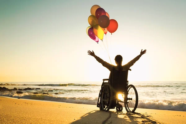 Handikappad Man Rullstol Med Färgade Ballonger Stranden — Stockfoto