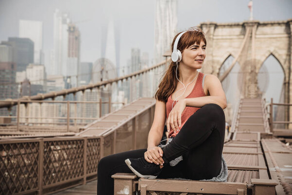 Woman sitting on the Brooklyn bridge and looking  the view