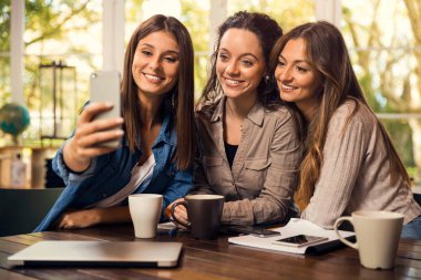 Dişi arkadaş grupları çalışmalara ara verilirken selfie çekiyorlar.