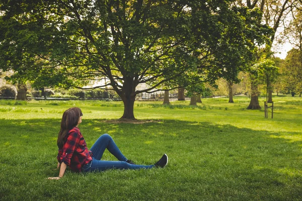 美丽的女人坐在河草和放松 — 图库照片