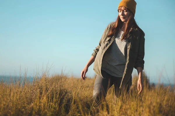 Hermosa Mujer Con Una Gorra Amarilla Caminando Sobre Hierba Alta —  Fotos de Stock