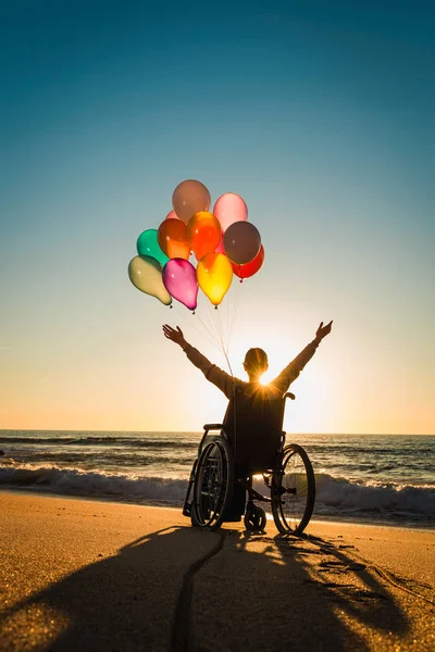 해변에서 풍선을 휠체어에 장애인 — 스톡 사진
